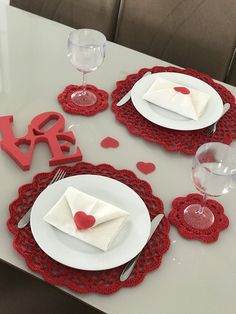 the table is set for valentine's day with red and white place settings on it