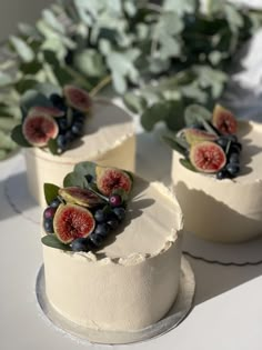 three cakes with figurines and berries on them