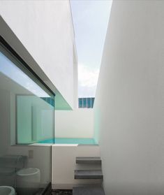 an outdoor area with rocks and stones on the ground, along with stairs leading up to a skylight