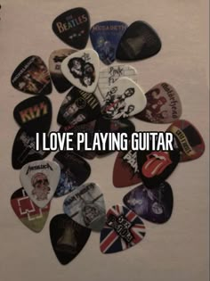 a bunch of guitar picks with the words i love playing guitar