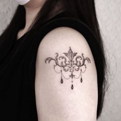 a woman's arm with a tattoo on it that has a chandelier