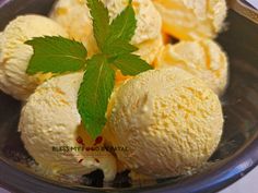 three scoops of ice cream in a bowl with a green leaf on the top