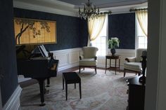 a living room filled with furniture and a chandelier hanging from the ceiling next to a piano