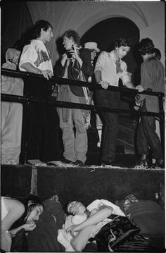 black and white photograph of people standing around a baby in a man's lap