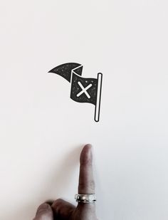 a hand is pointing at a black and white flag that has been drawn on it