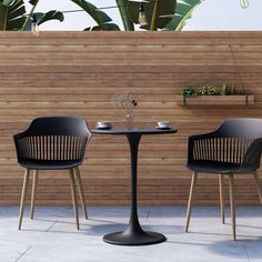 two chairs and a table in front of a wooden fence