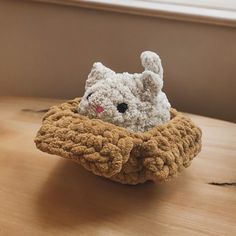 a crocheted bunny in a basket on a table