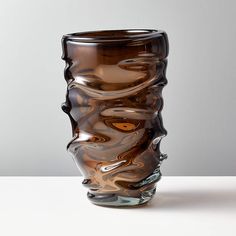 a brown glass vase sitting on top of a white table