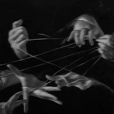 an artistic black and white photo of hands holding strings