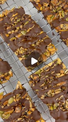 chocolate covered cookies on a cooling rack with nuts and other toppings in the background