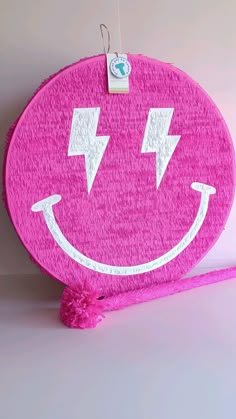 a pink towel with a smiley face drawn on it's side and two lightning bolts in the middle