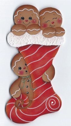 two gingerbreads are sitting on top of a red christmas stocking