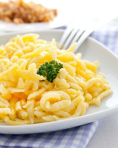 a white plate topped with macaroni and cheese next to a bowl of broccoli