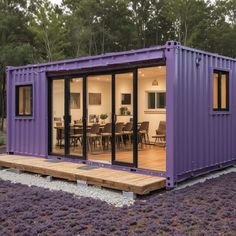 a large purple container house sitting on top of a field