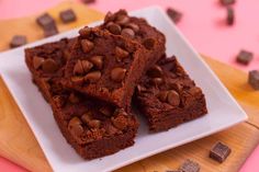 some brownies are on a white plate with chocolate chips