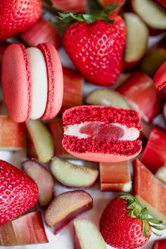 strawberry shortcakes and macaroni shells are arranged on a white surface with strawberries in the background