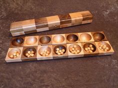 an assortment of wooden bowls and spoons on top of a brown tableclothed surface