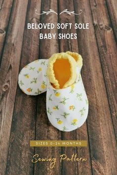 a pair of baby shoes sitting on top of a wooden floor with the words below it