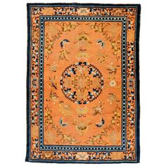 an orange rug with blue border and floral design