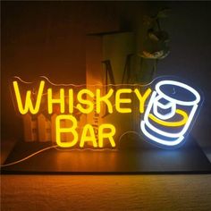 a neon sign that says whiskey bar with a lit up beer mug on the front