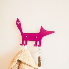 a coat rack with a pink dog on it and a key hanging from the hook