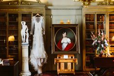 a room filled with lots of bookshelves covered in pictures and dresses hanging on the walls