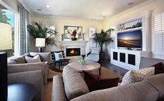 a living room filled with furniture and a flat screen tv mounted on the wall above a fire place