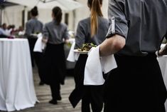 waiters are carrying plates with food on them