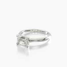 a white gold engagement ring with a princess cut diamond in the center and side stones