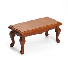 a small wooden bench with scalloped legs and a leather seat cushion on the bottom