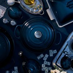 an assortment of cooking utensils and other kitchenware on a table top,