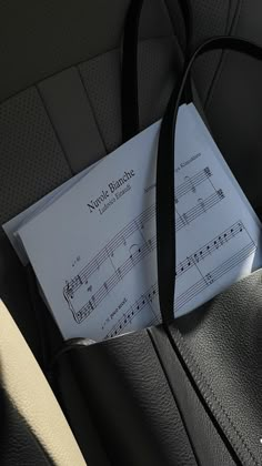 an envelope with sheet music on it sits in the back seat of a car