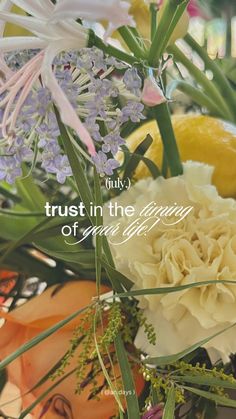 a vase filled with flowers and fruit on top of a table