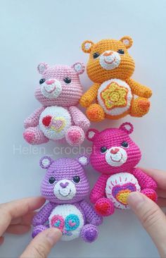 four crocheted teddy bears sitting in the palm of a person's hand