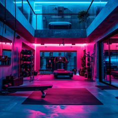 an indoor gym with pink lighting and exercise mats on the floor in front of it