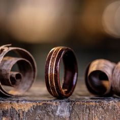 three wooden rings sitting on top of a piece of wood