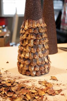 two decorative vases sitting on top of a table next to each other, with shells scattered around them