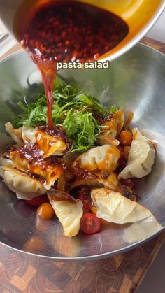 someone is pouring sauce on some food in a bowl