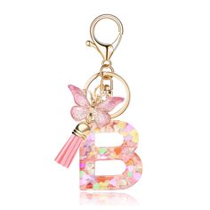 a gold key chain with a pink butterfly on it's letter f and a tassel