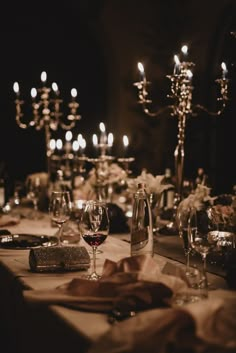 the table is set with wine glasses, candles and napkins for an elegant dinner