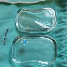 two glass dishes sitting on top of a blue towel