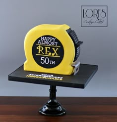 a yellow and black birthday cake with the words happy almost r ex on it