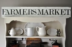 a shelf filled with dishes and cups on top of a wooden sign that says farmers market