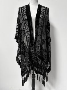 This shawl is absolutely LUSH...very reminiscent of fabulous piece from early 1900s. Would work beautiful over a nice dress or as a robe. The fabric is slightly sheer black base with an all over black velvet floral pattern and trim. All along the bottom is lovely diamond fringe to really seal the glamorous look of this piece. It is one size fits all (yes, really! S-5X) and does feature armholes for ease of wear. It is NOT at all fitted and it does have armholes and it functions more like a cape/ Soft Goth Glam Outfit, Black Fringed Shawl For Festival, Elegant Black One-size Shawl, Dark Victorian Aesthetic Outfit, Dark Victorian Aesthetic, Goth Glam, Glam Outfit, Shawl Cardigan, Clothing Hacks