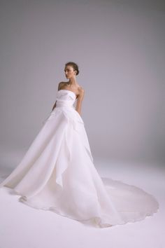 a woman in a white wedding dress posing for the camera