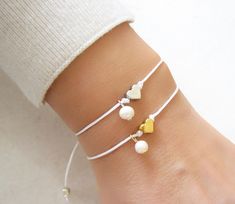 Gold Heart Bracelet, Friendship Bracelet, Love Bracelet, Gift For Her, Bridesmaid Gifts, Wish Bracelet A lovely bracelet which you can wear alone or together with others! ♥ Made from 6mm silver or gold plated heart charm with or without a freshwater pearl. ♥ 1mm Satin cord. ♥ Two gold plated beads at the ends. ♥ The bracelet is adjustable and it closes with a macrame knitting. WRAPPING - All ZafireniaDainty jewelry arrive gift wrapped in a cute bag or box ready for giving. PRODUCTION TIME - Ever Gold Handmade Adjustable Heart Bracelet, Handmade Adjustable Minimalist Heart Bracelet, Dainty Heart-shaped Beaded Bracelet For Friendship, Dainty Adjustable Heart Bracelet - Gift For Her, Dainty Adjustable Heart-shaped Bracelet, Macrame Knitting, Silver Heart Jewelry, Gold Heart Bracelet, Rhinestone Choker Necklace