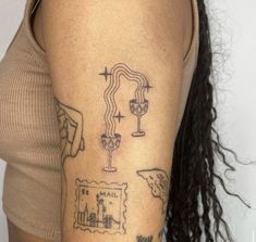 a woman's arm with tattoos on it, including a wine glass and map