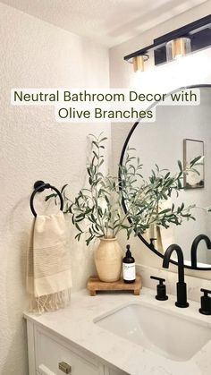 a bathroom with white counter tops and black faucets on the sink, surrounded by greenery