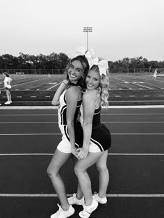 two young women standing on top of a tennis court