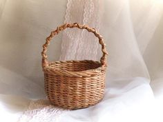 a wicker basket sitting on top of a white sheet